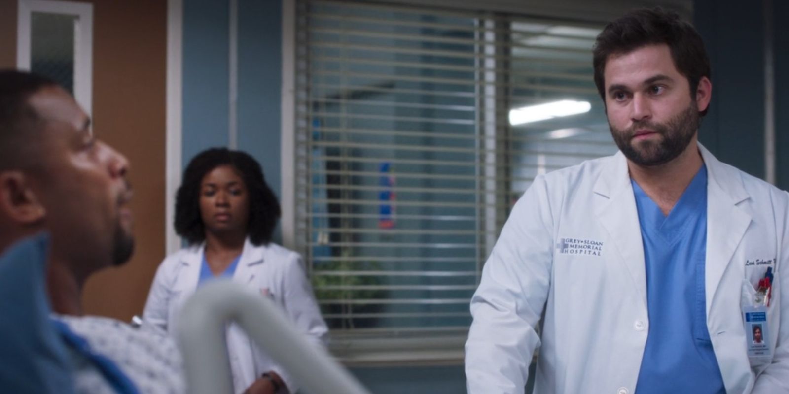 Jake Borelli As Levi Schmitt With Simone In Background In Grey's Anatomy.jpg