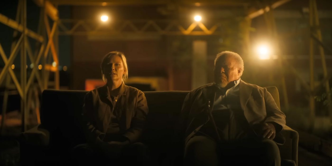 Kirsten Dunst e Stephen McKinley Henderson sentam-se em uma sala mal iluminada em Guerra Civil (2024)
