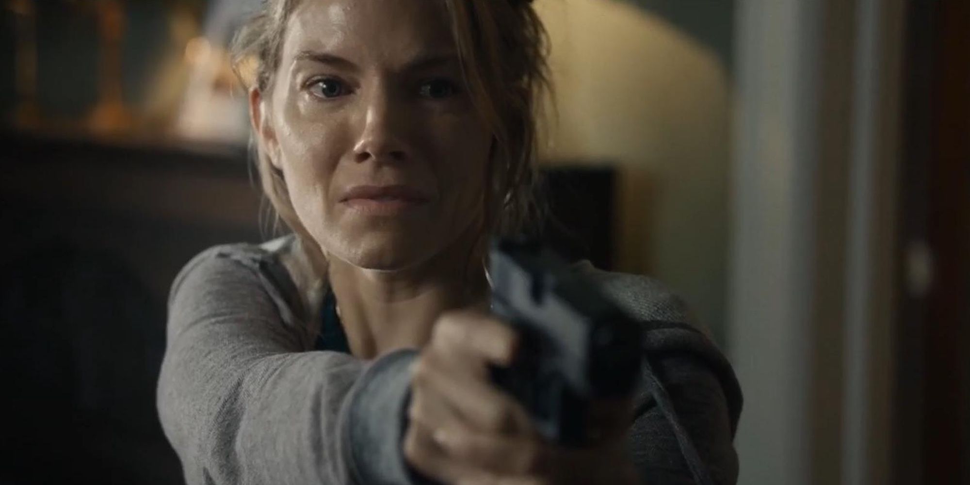 Sienna Miller pointing a gun in 21 Bridges