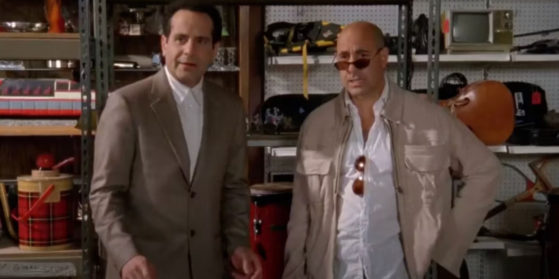 Stanley Tucci and Tony Shalhoub standing together in Monk's warehouse