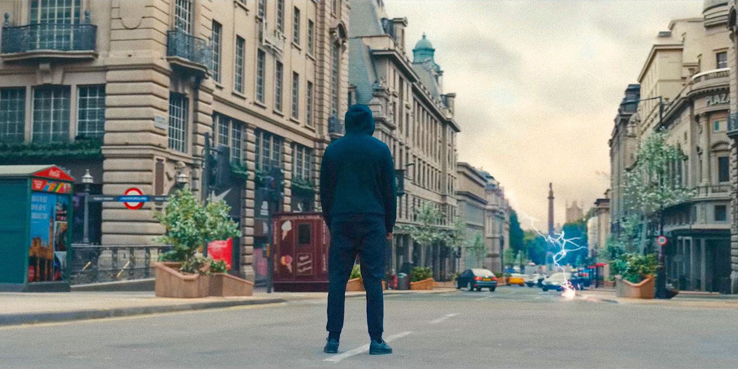 Um homem vestido de preto observa um raio cair no final da rua em Supacell