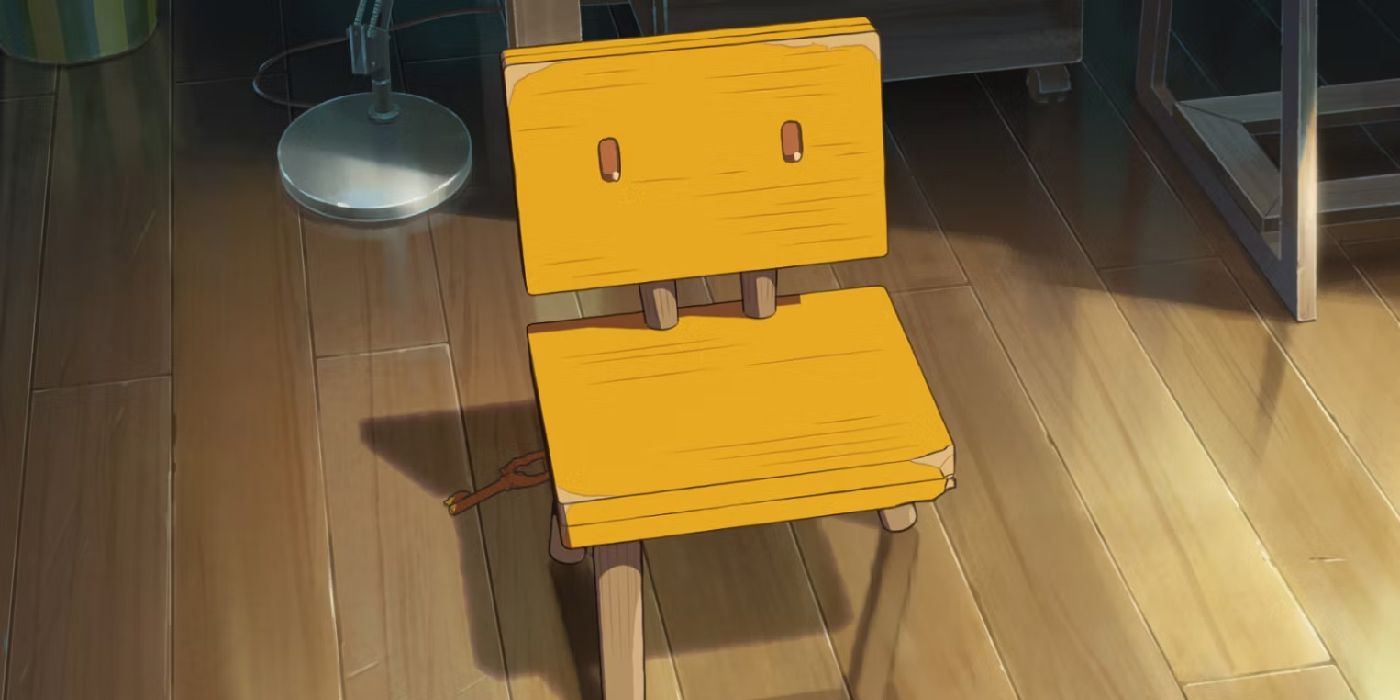 Kursi kuning berdiri di atas lantai kayu dari film Suzume.