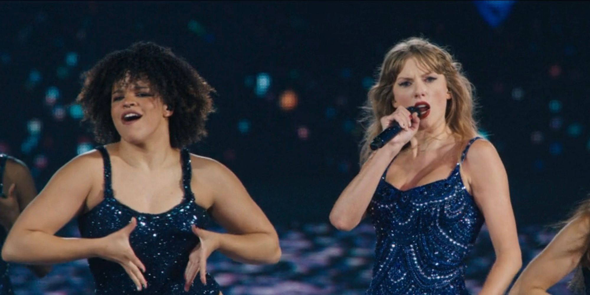 Taylor Swift performs with backup dancer Tamiya Evans in The Eras Tour movie.