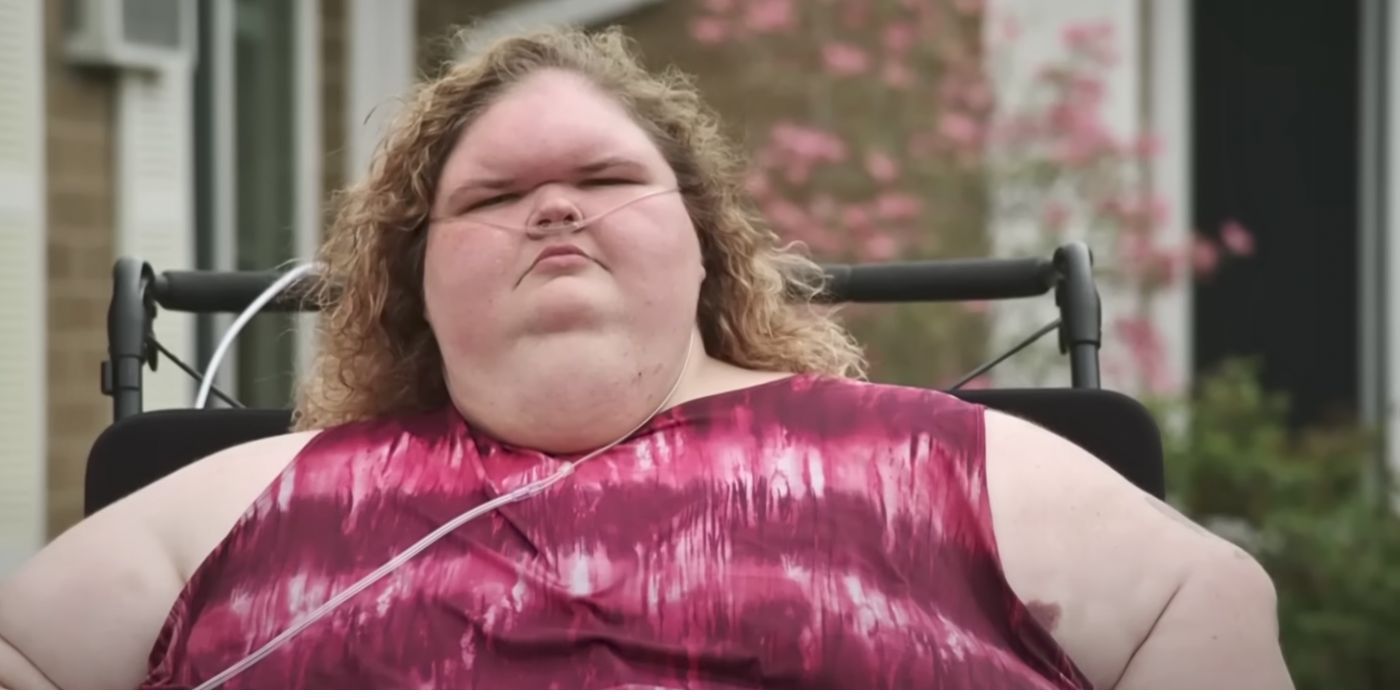 Tammy Slaton 1000-Lb Sisters looking angry sitting in a wheelchair with sleeveless red and white top