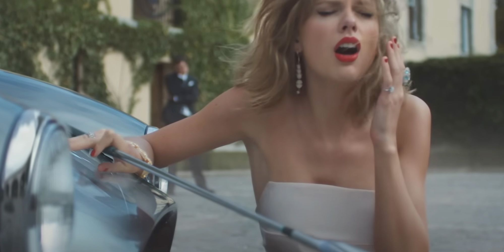 Taylor Swift holding a golf club and sitting next to a car in the Blank Space music video