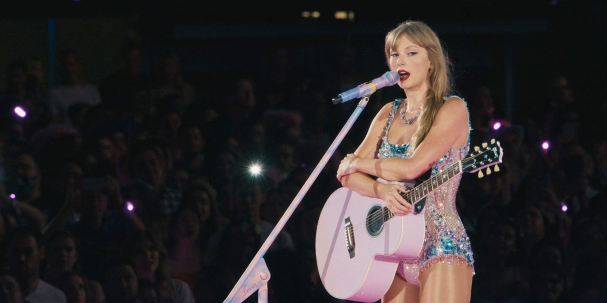Taylor Swift with a pink guitar in The Eras Tour