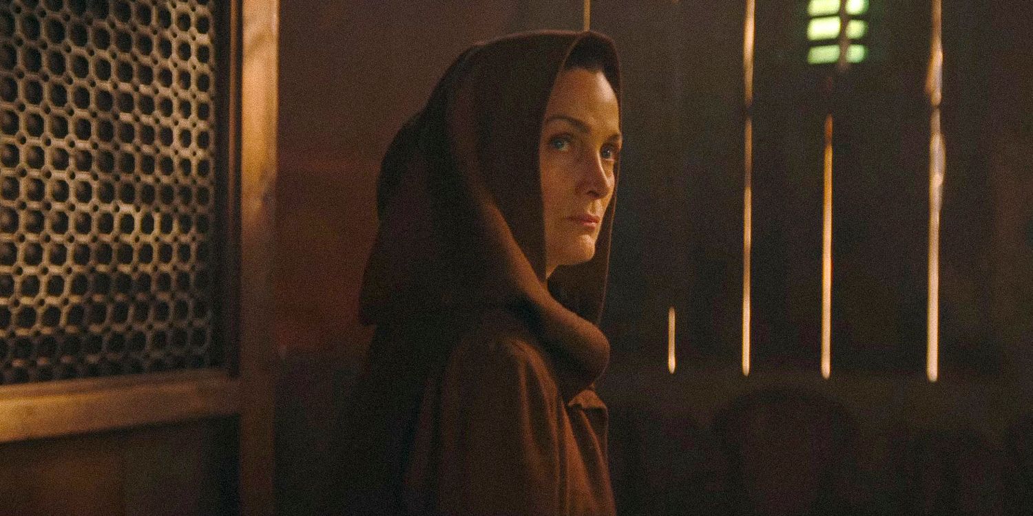 Carrie-Anne Moss as the Jedi Master Indara from The Acolyte looking out from under her hood