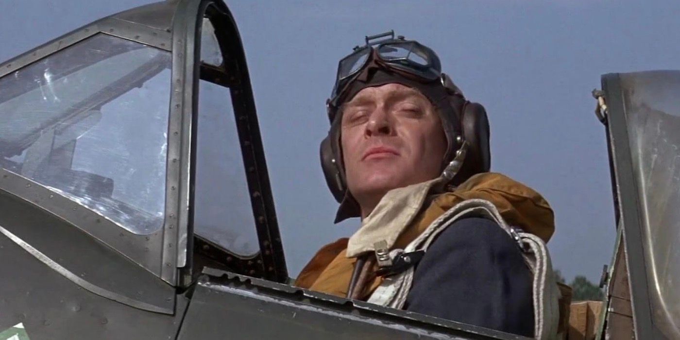 Michael Caine is sitting in an aircraft and squinting from the sun. 