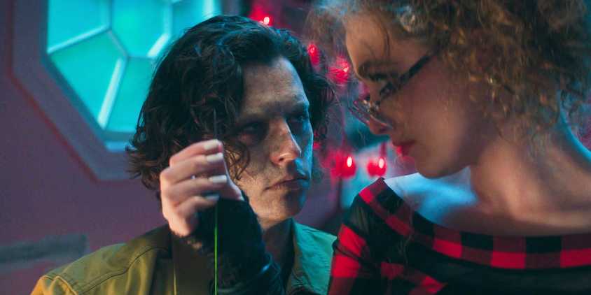 The Creature looking at Lisa with a needle and thread in her hand in Lisa Frankenstein
