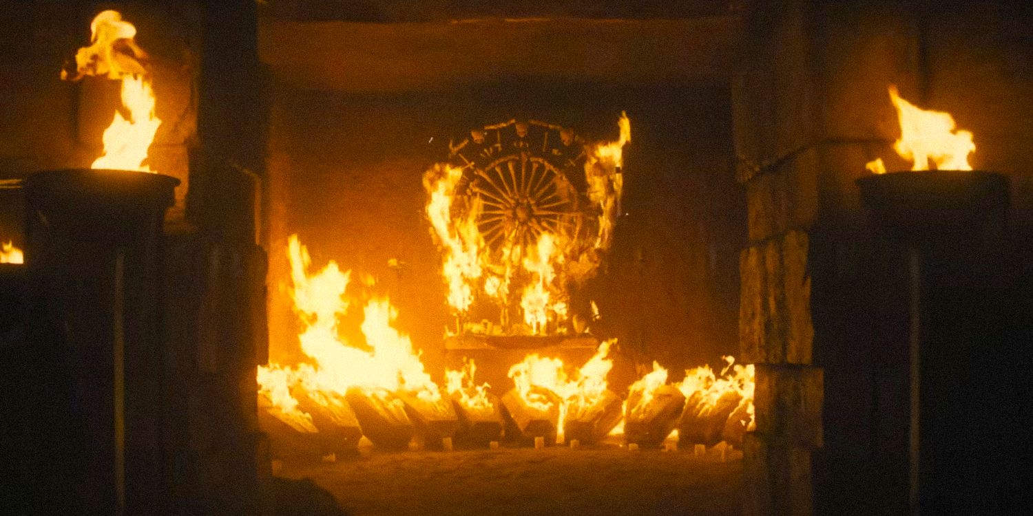 An altar of bones, skulls, and coffins burning in fire in The First Omen.