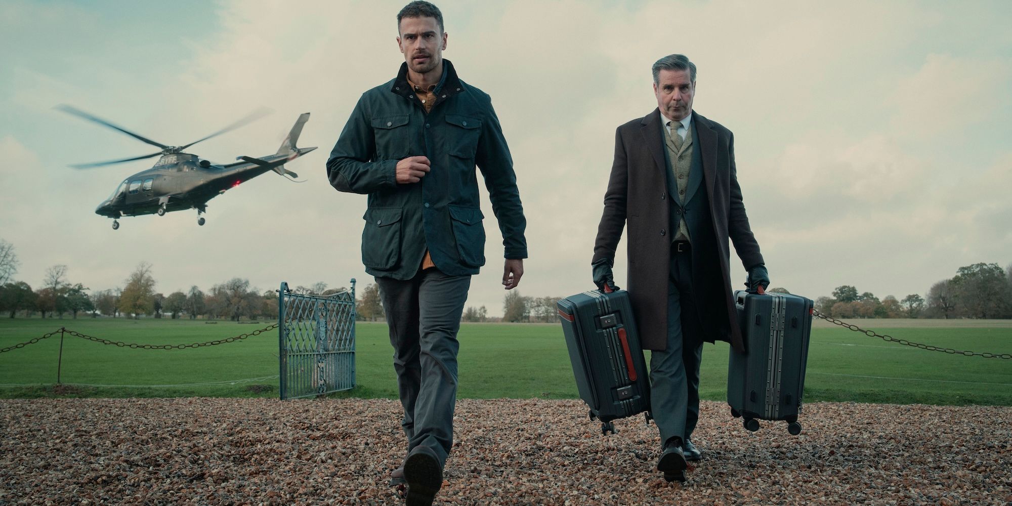 Theo James walks away from a helicopter with a man holding his suitcases in The Gentlemen series