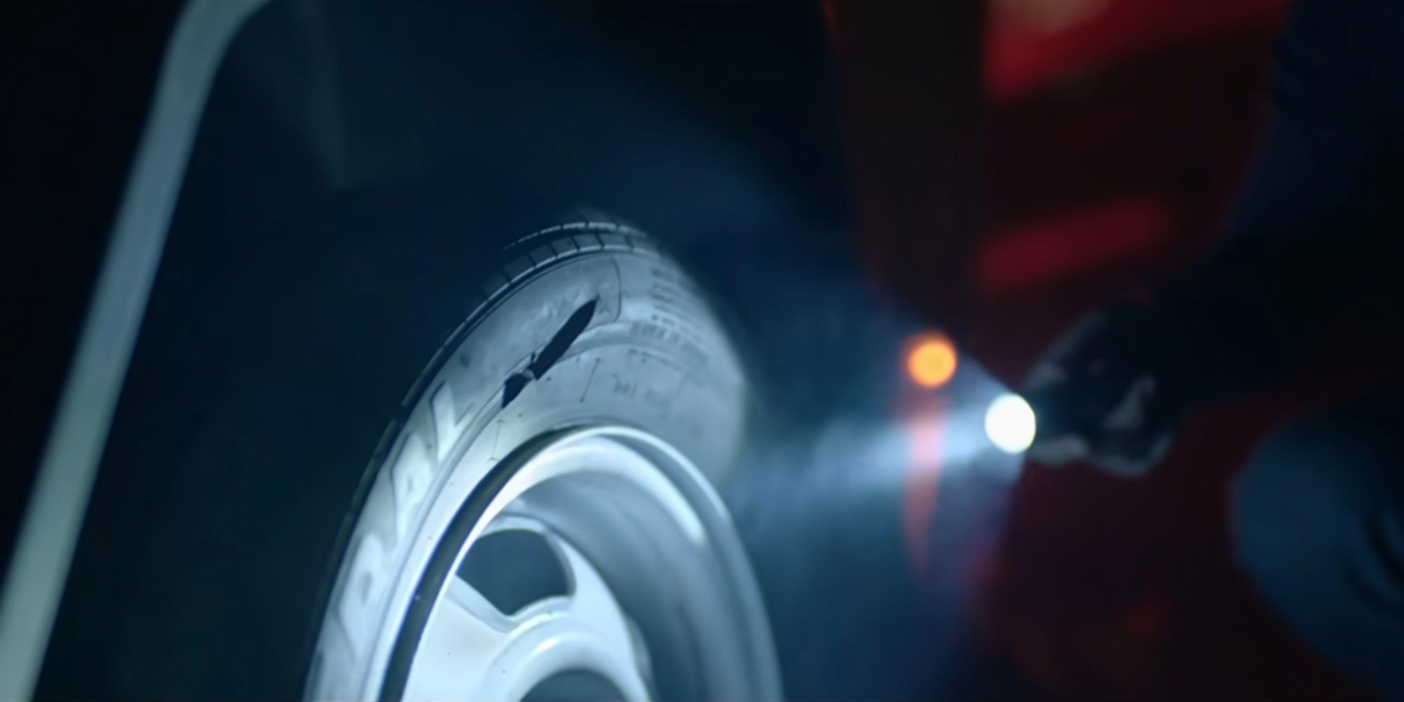 A flashlight is flashed on a slashed tire in Alone (2020).