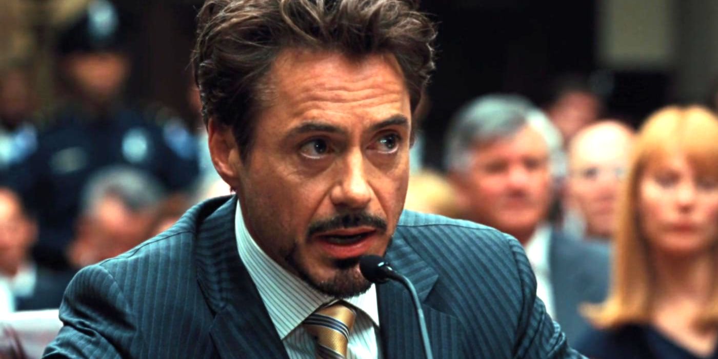 como Tony Stark participando de uma audiência e falando ao microfone em Homem de Ferro 2 (2010)