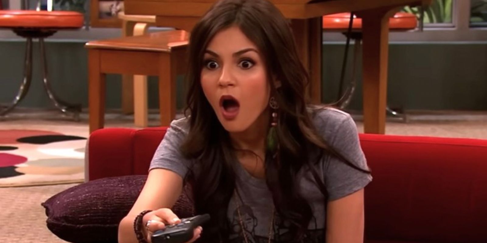 Tori pointing a TV remote and appearing shocked in Victorious