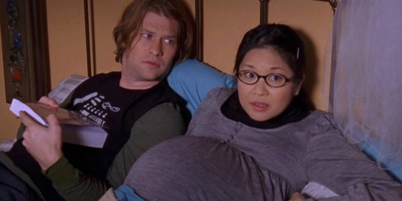 A pregnant Lane and Zach lying in bed together in Gilmore Girls