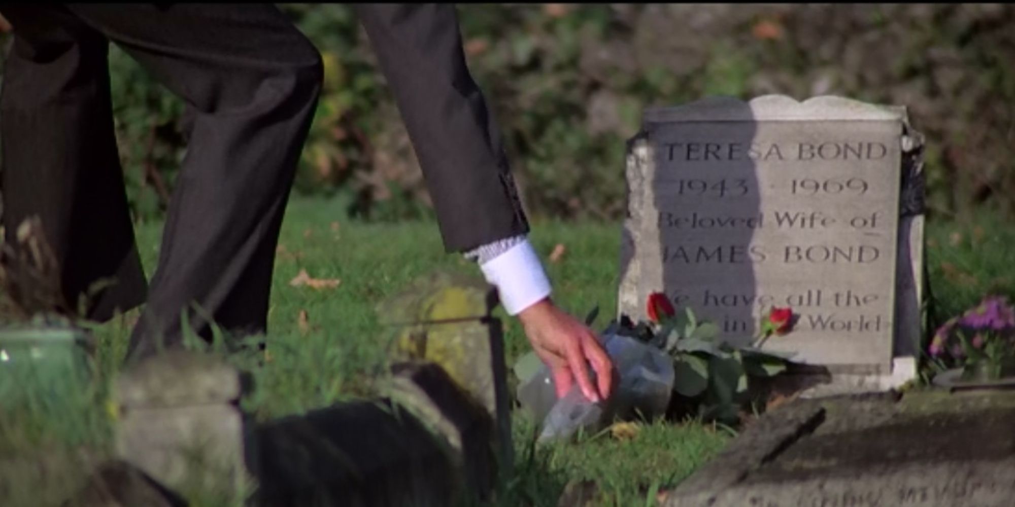 Roger Moore placing flowers on Tracy's grave as James Bond in For Your Eyes Only