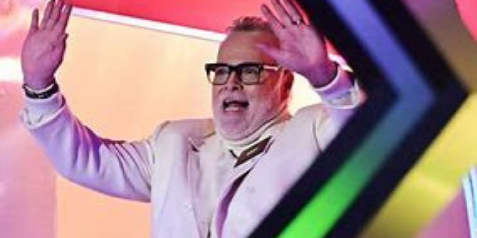 Celebrity Big Brother UK Gary Goldsmith in a light colored suit against a colorful background