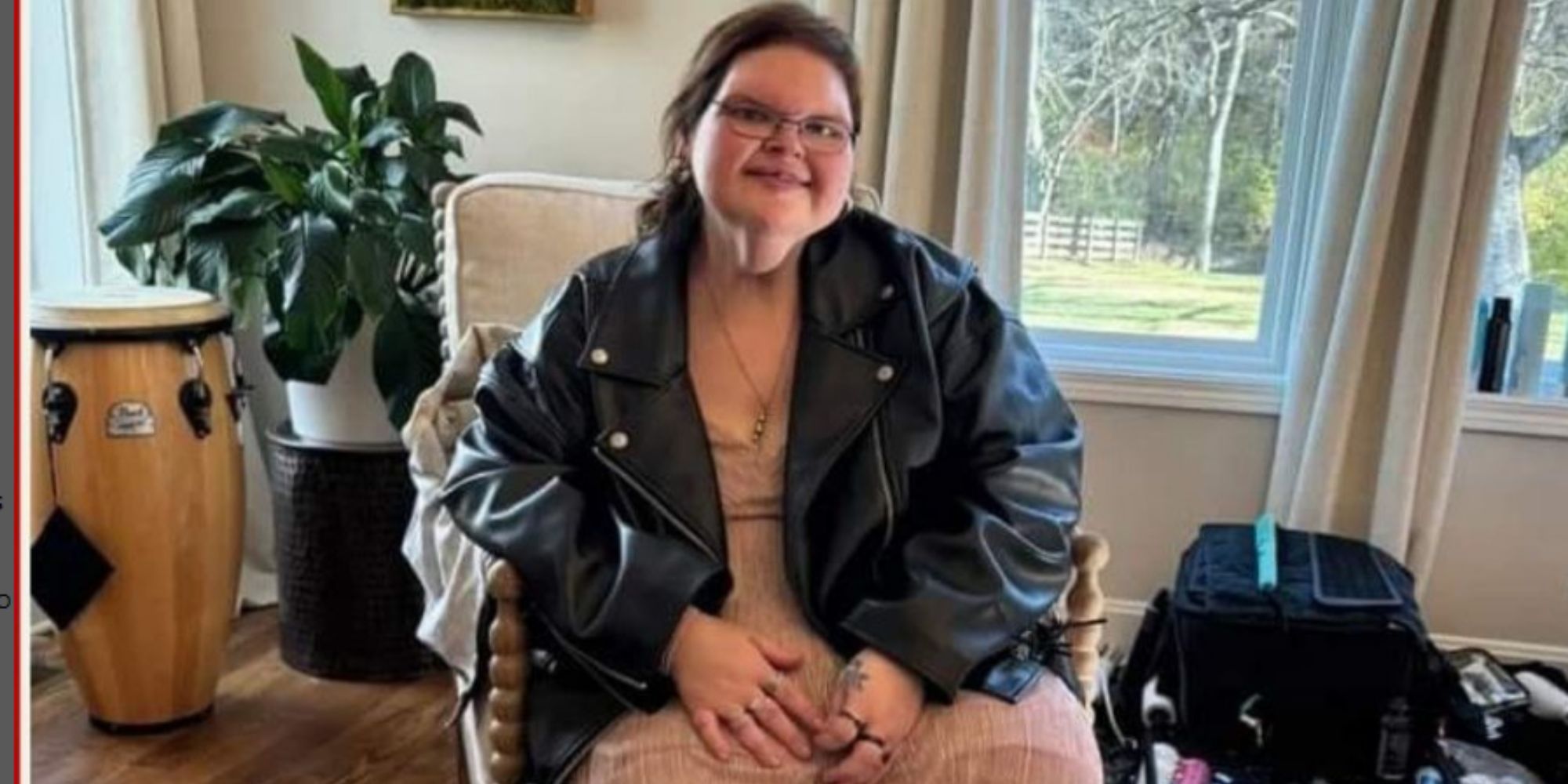 1000-lb sisters tammy slaton in black leather jacket seated in a living room with a window in background