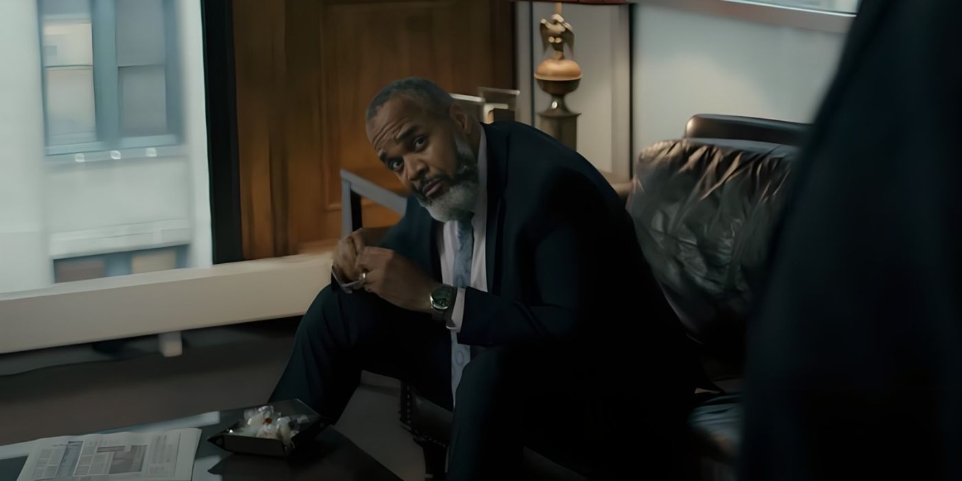 Victor Williams como Wendell Robinson inclinado em um sofá e olhando para alguém fora da tela em Justified City Primeval.