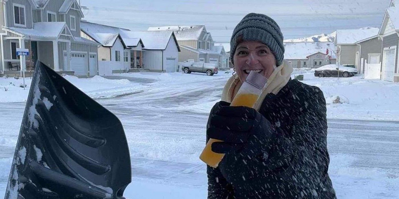 Christine Brown, da Sister Wives, sorrindo enquanto segura uma pá e uma garrafa de bebida