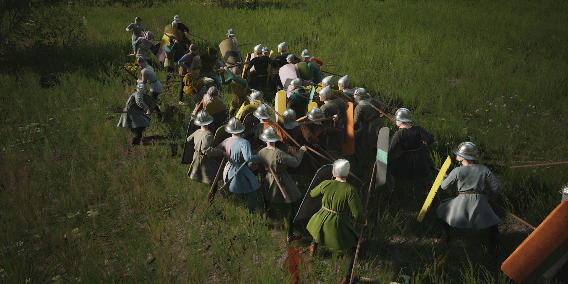 Uma multidão caótica de milicianos com lanças em um campo gramado em uma captura de tela de Manor Lords.