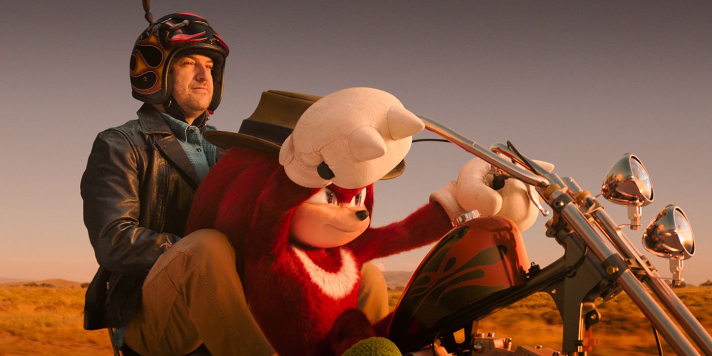 Adam Pally as Wade looking happy riding on the back of a motorcyle with Knuckles in Knuckles