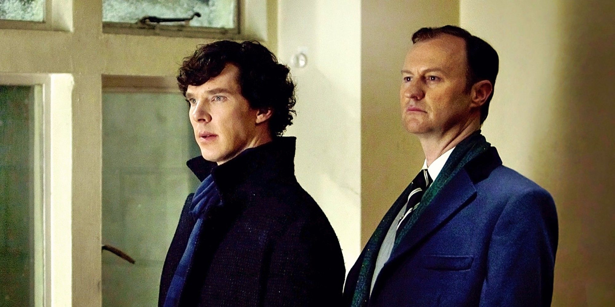 Benedict Cumberbatch and Mark Gatiss as Sherlock and Mycroft Holmes standing and looking off in the same direction in Sherlock season 2