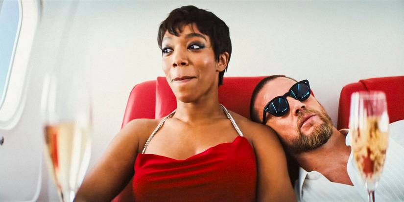 Frida (Naomi Ackie) bites her lips in excitement while Slater King (Channing Tatum) leans on her shoulder in Blink Twice (2024)