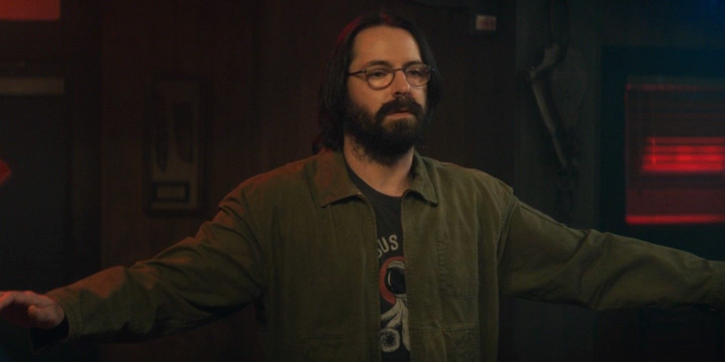 Bodhi (Martin Starr) stands with his arms spread out while being searched in Tulsa King