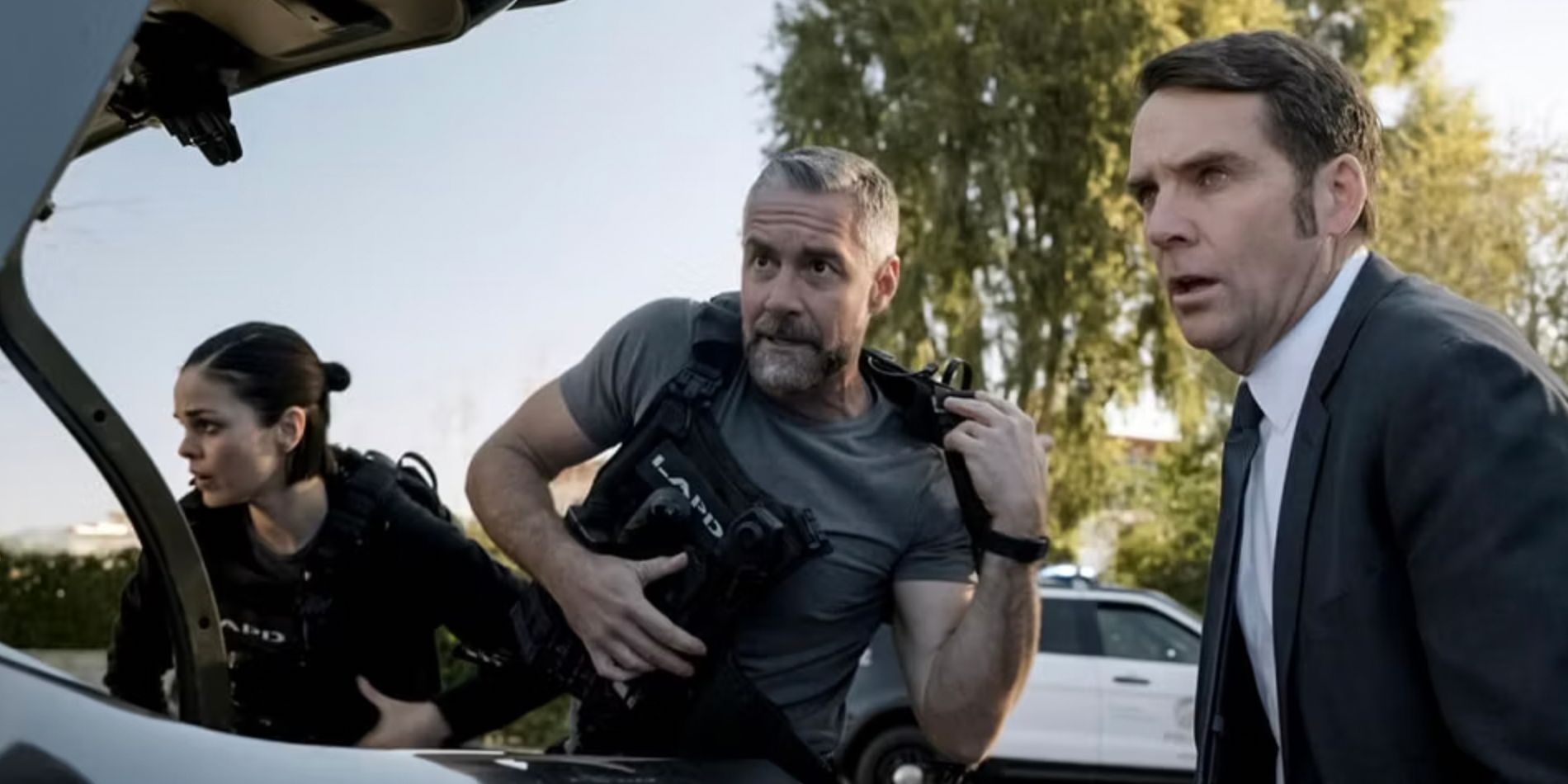 Chris e Deacon vestiram seus coletes ao lado de um homem de terno no episódio Stigma-1 da SWAT