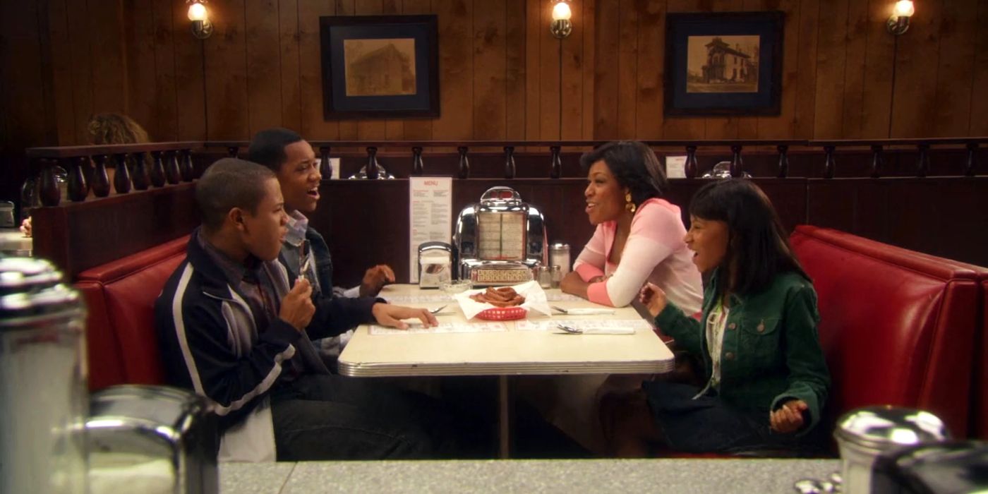 Chris' (Tyler James Williams) family sitting around a restaurant table laughing in the final scene of Everybody Hates Chris.