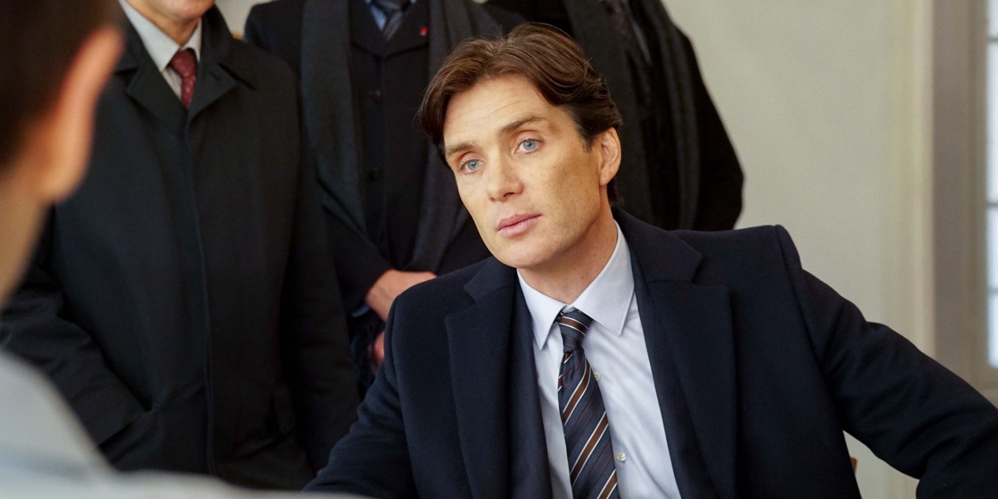 Cillian Murphy sitting at a table looking at somebody as Miller in Anna (2019)