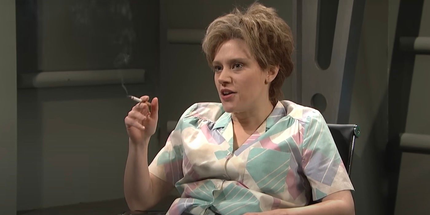 Kate McKinnon is sitting down with a cigarette in her hand. 