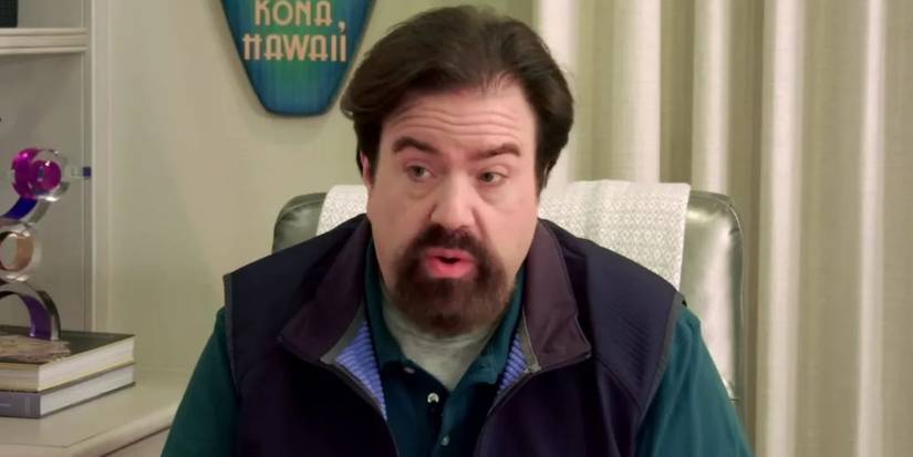 Dan Schneider sitting in a chair speaking to someone off camera