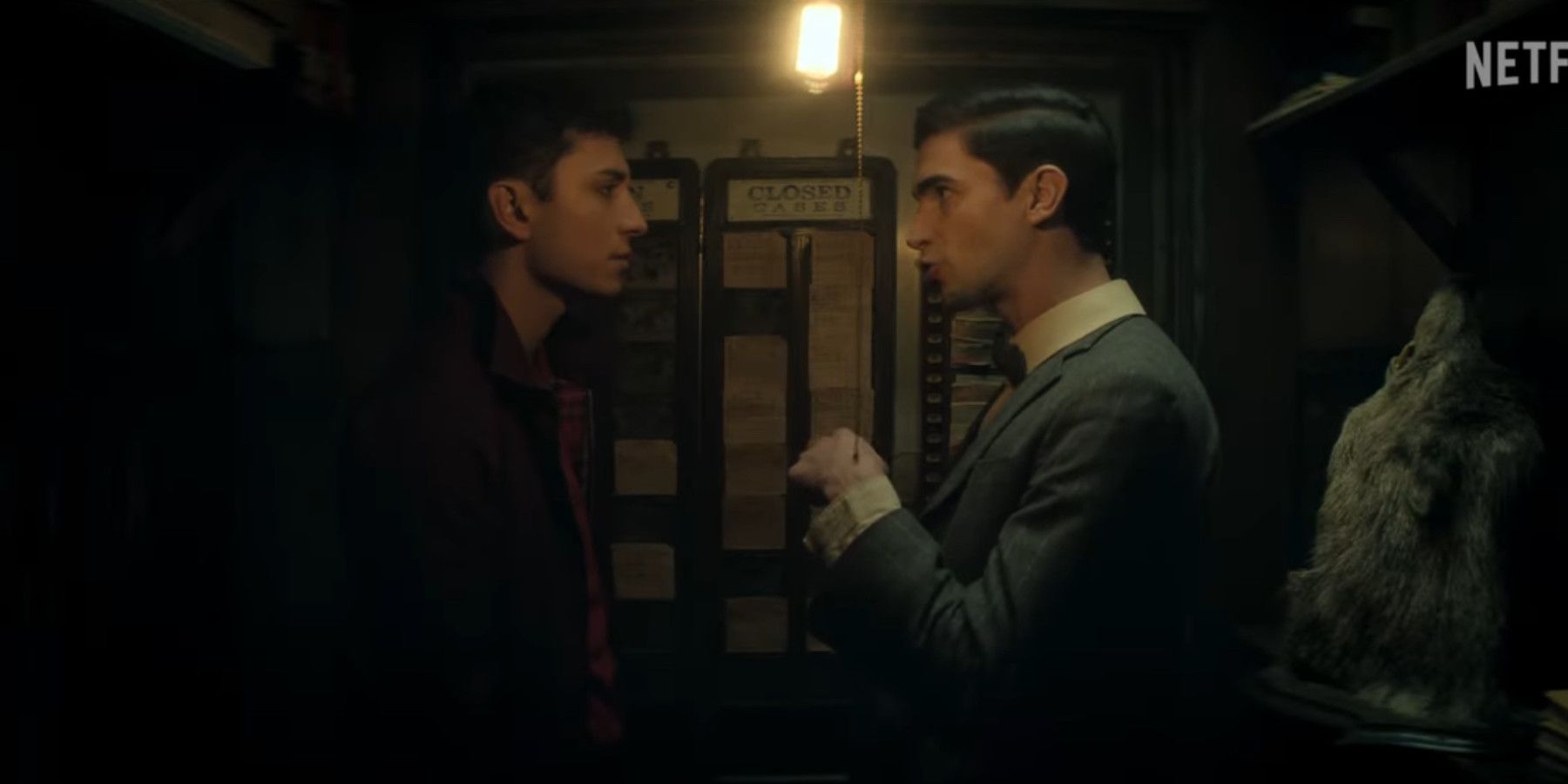 Dead Boy Detectives scene shows lead characters Edwin Paine and Charles Rowland in a closet illuminated by a lightbulb