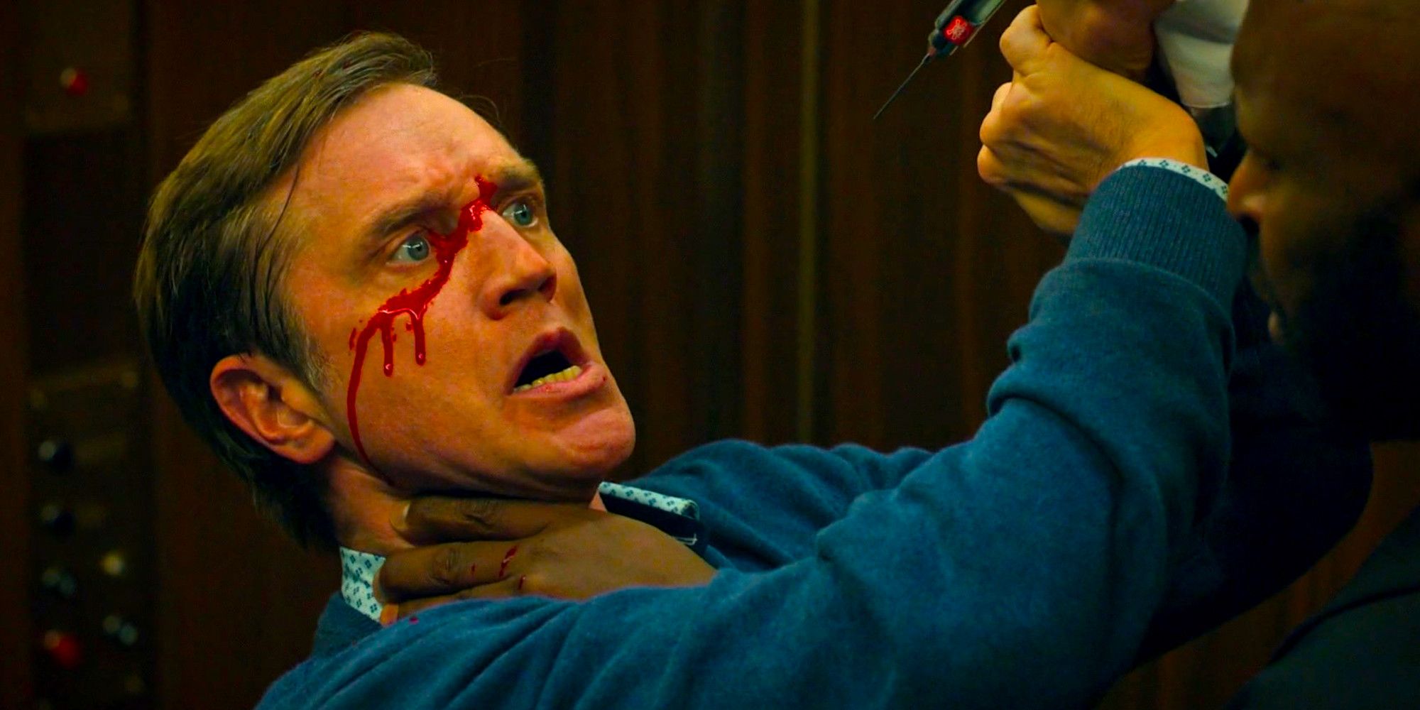 Blood drips on Devon Sawa's face as he fights a man in an elevator in a scene from Chucky season 3