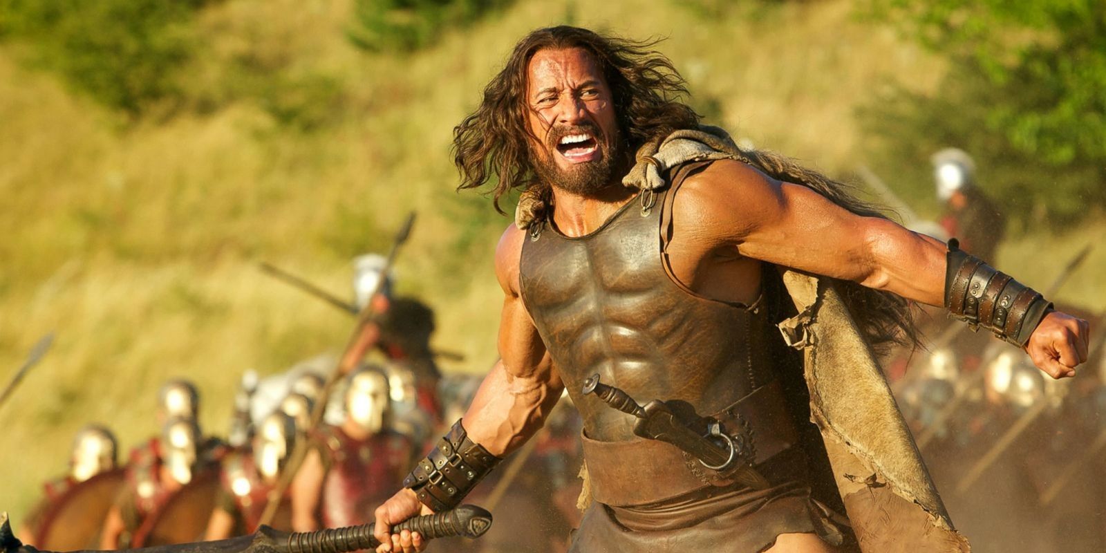 Dwayne Johnson as Hercules in an action scene yelling and waving a weapon