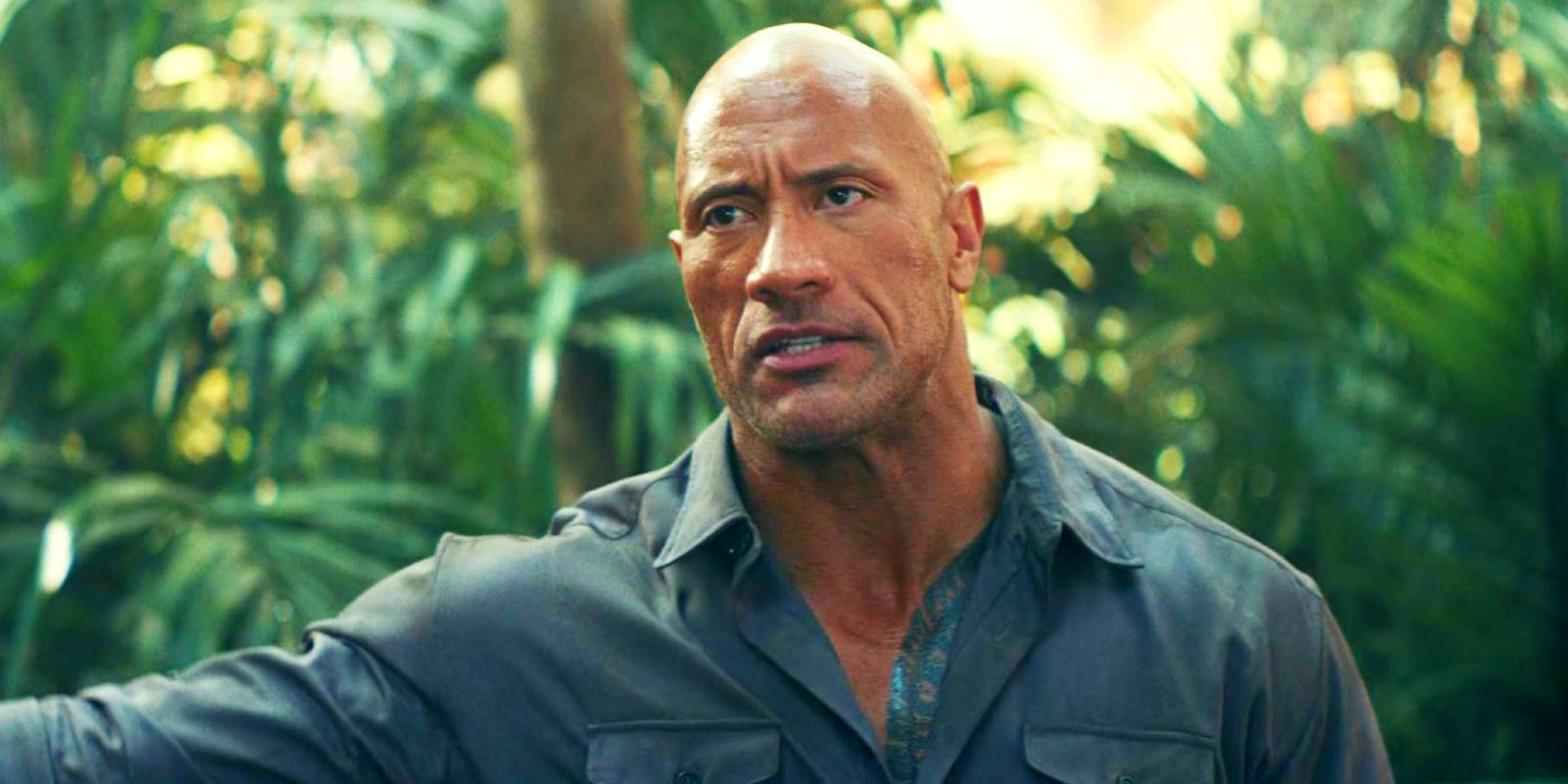Dwayne Johnson pointing at something in the jungle in Red Notice