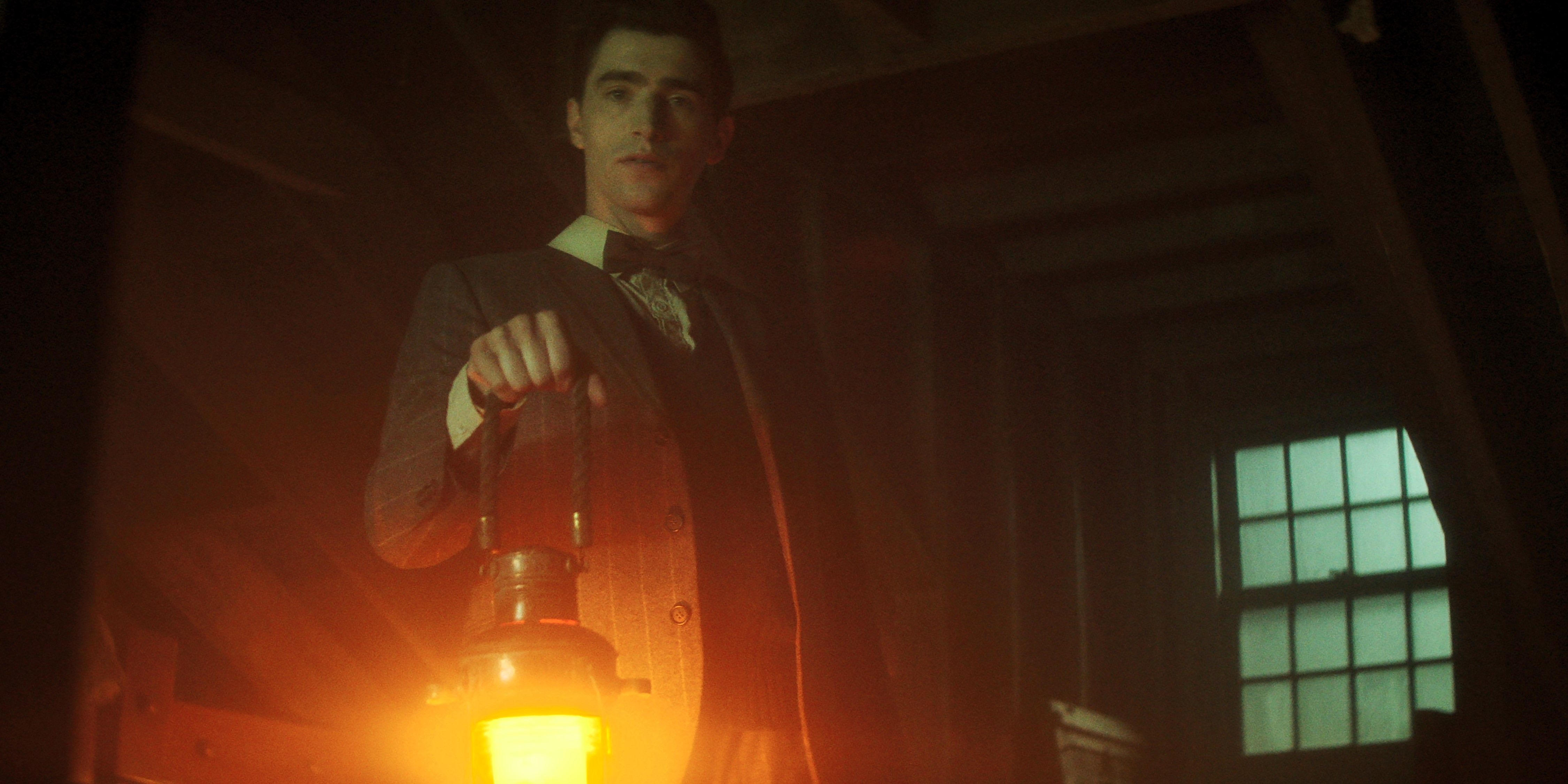 Edwin segura uma lanterna em um quarto escuro em Dead Boy Detectives