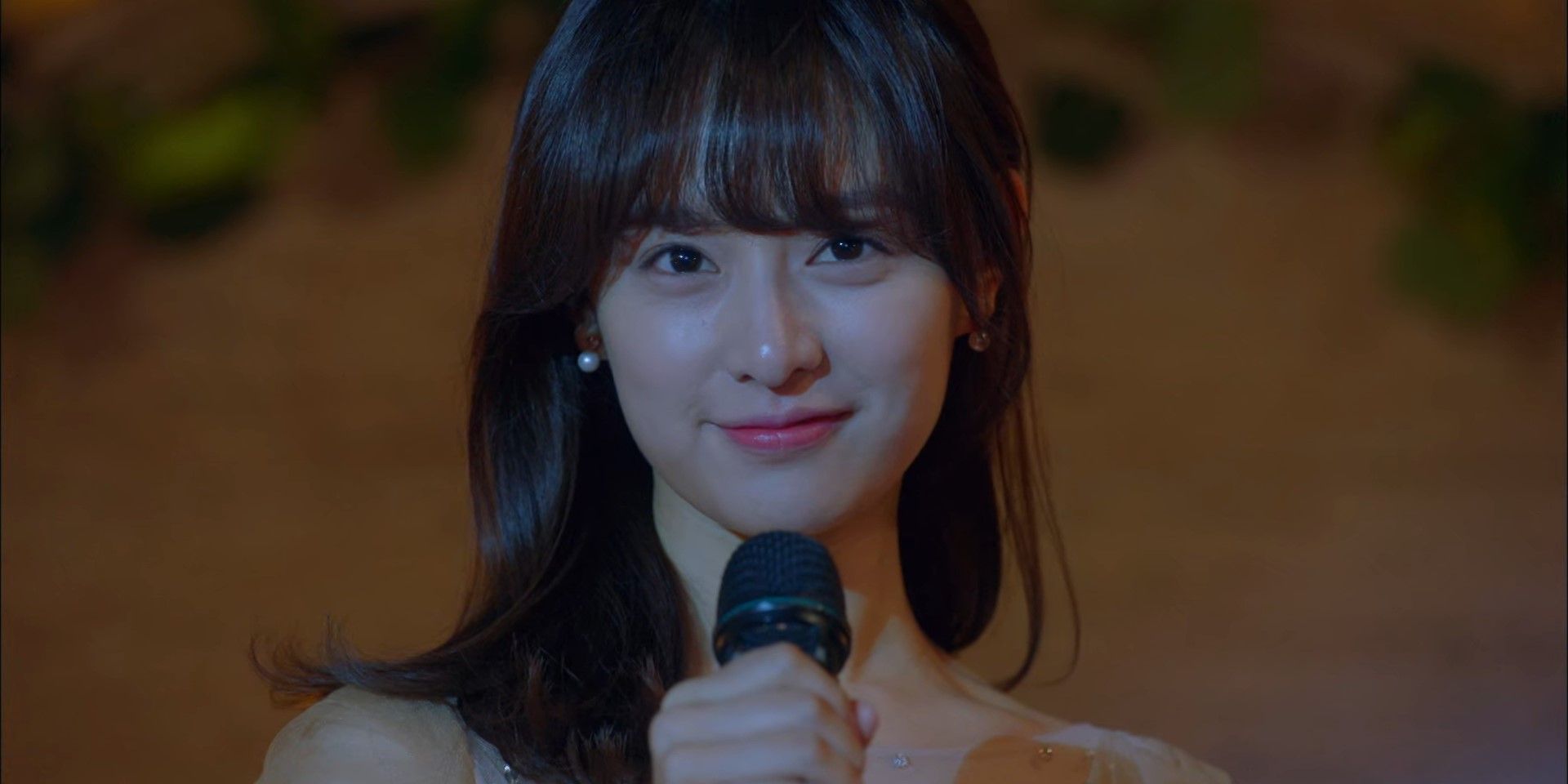Choi Ae-ra memegang mikrofon dan tersenyum di Fight For My Way