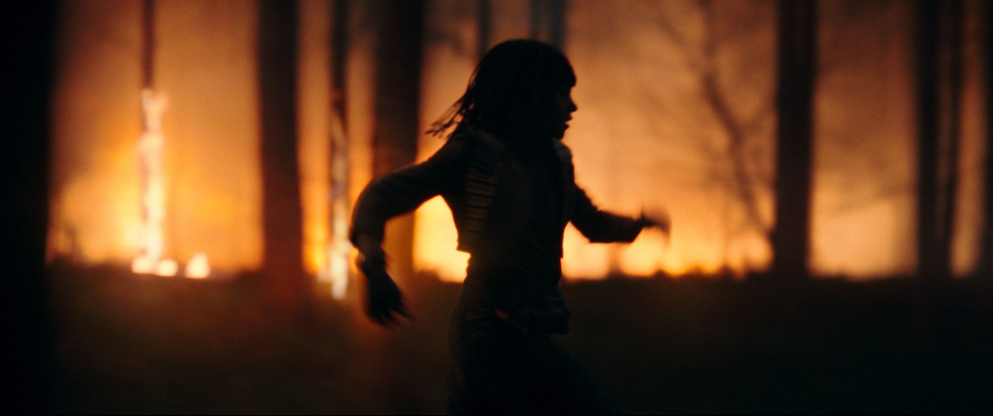 Alguém, possivelmente Mae, corre paralelo a um fogo que arde em uma floresta em Star Wars: The Acolyte