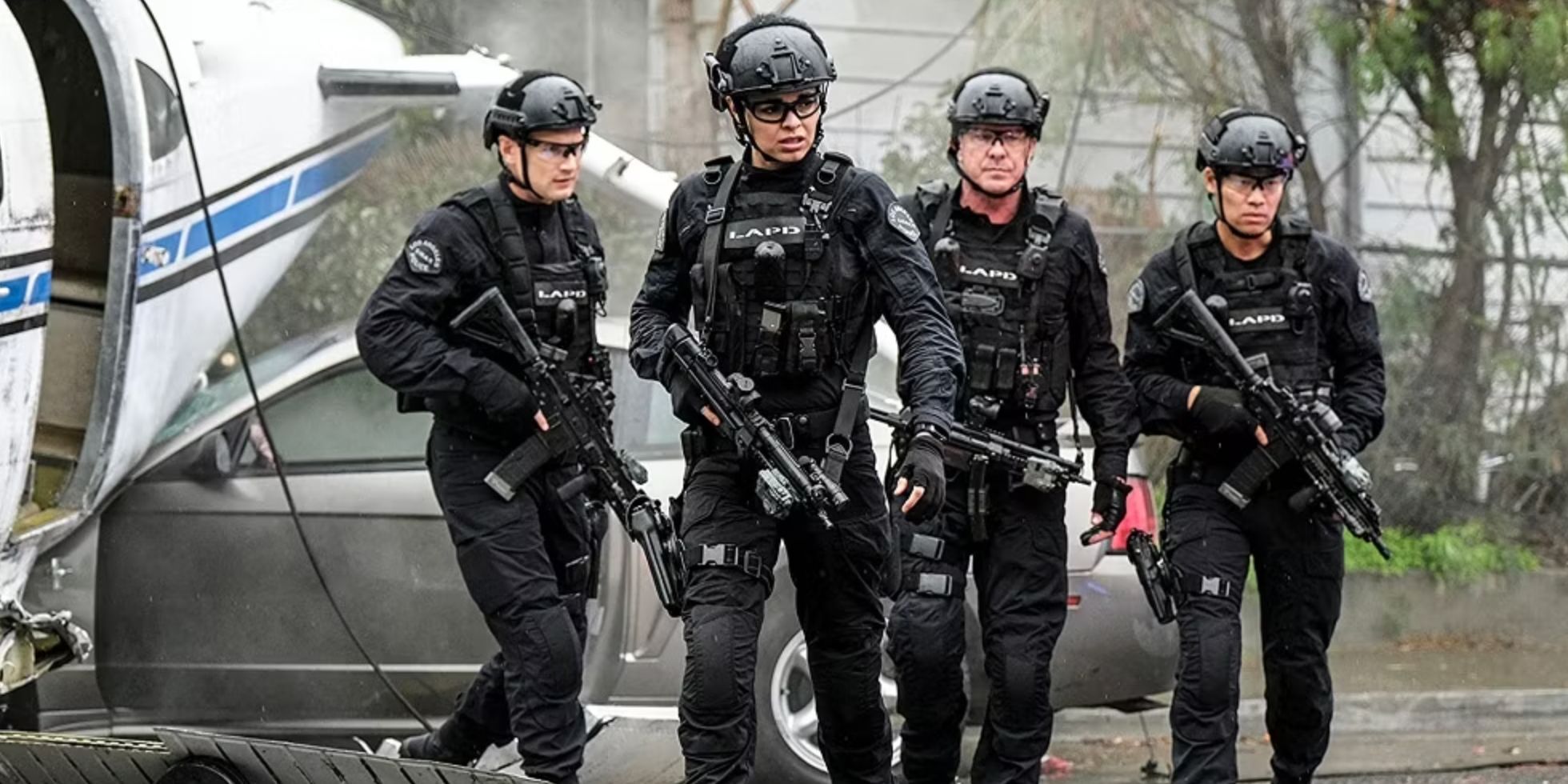 Quatro membros da equipe principal de oficiais em seus equipamentos brandindo armas ao lado de uma aeronave caída no episódio Diablo da SWAT