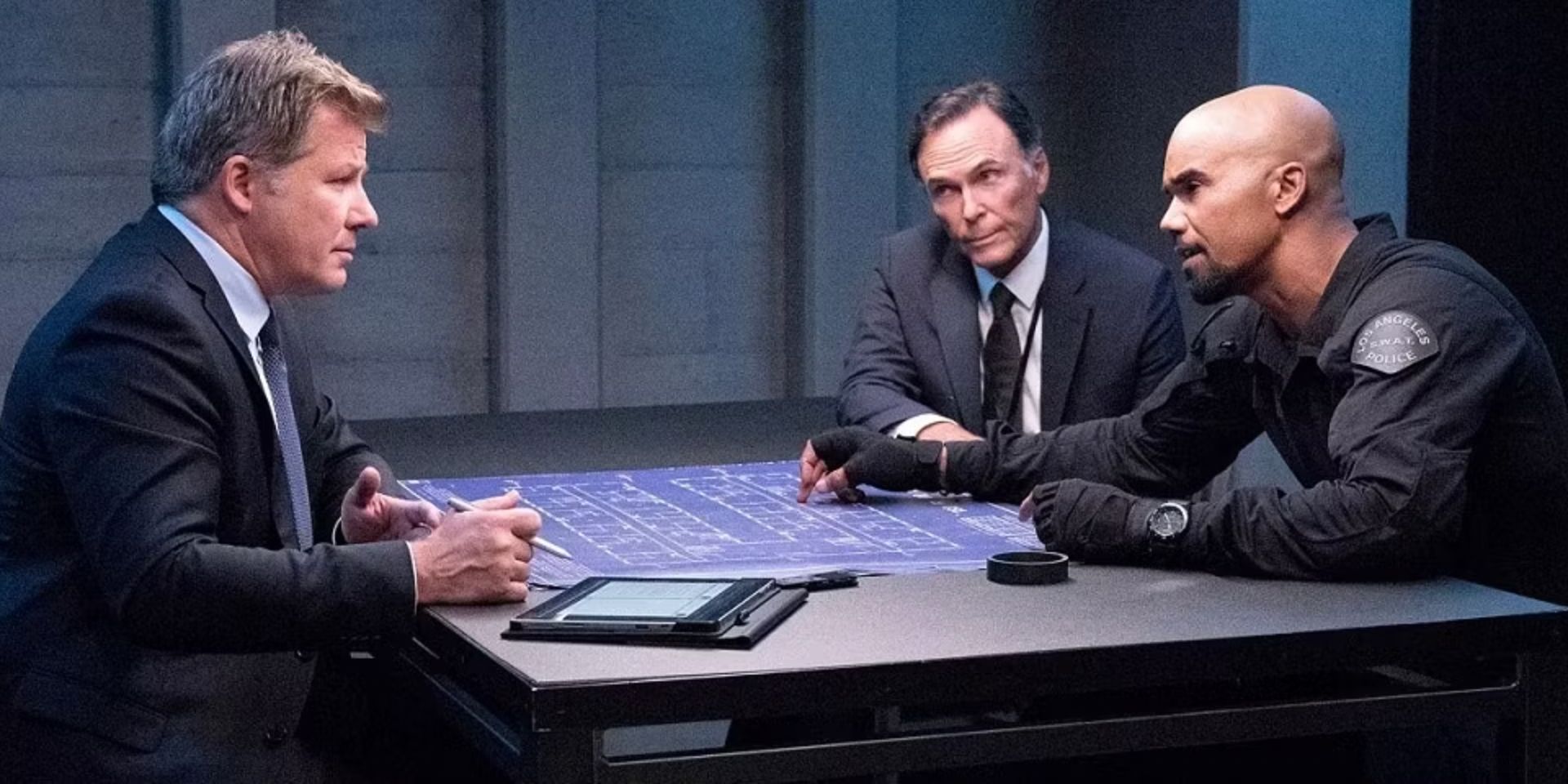 Hondo é interrogado com um conjunto de plantas na mesa à sua frente no episódio da SWAT Day of Dread