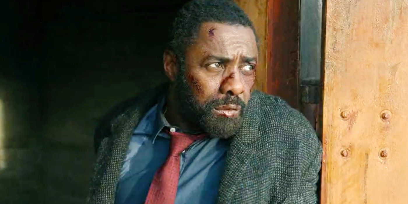 Idris Elba looking battered and beat up while hiding behind a wall in Luther