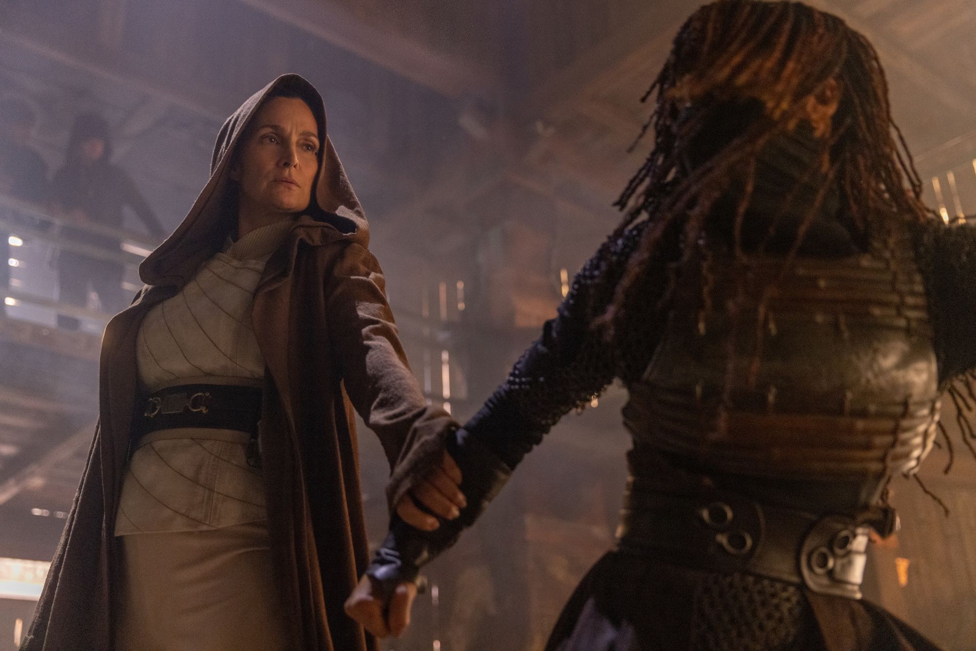 A Mestre Jedi Indara (Carrie-Anne Moss) segura o pulso de Mae (Amandla Stenberg) durante sua luta dentro de casa em Star Wars: The Acolyte