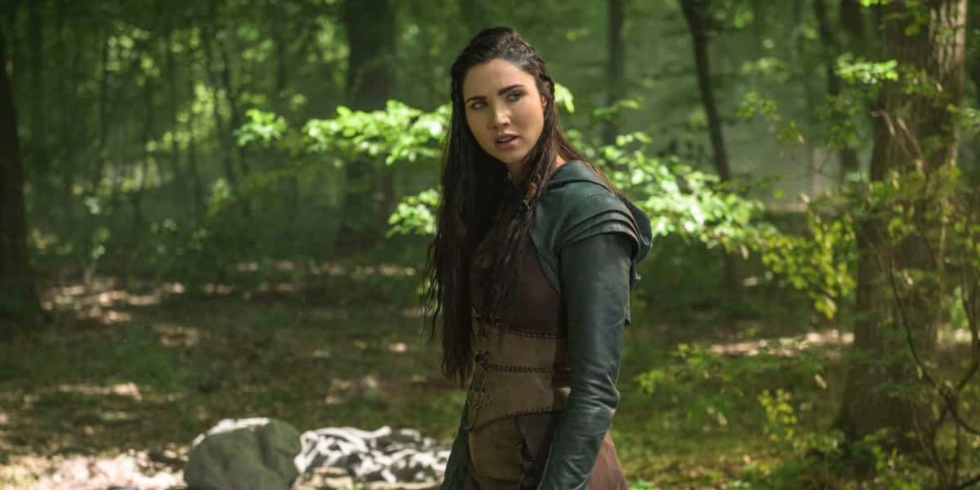 Jessica Green olha por cima do ombro na floresta em The Outpost