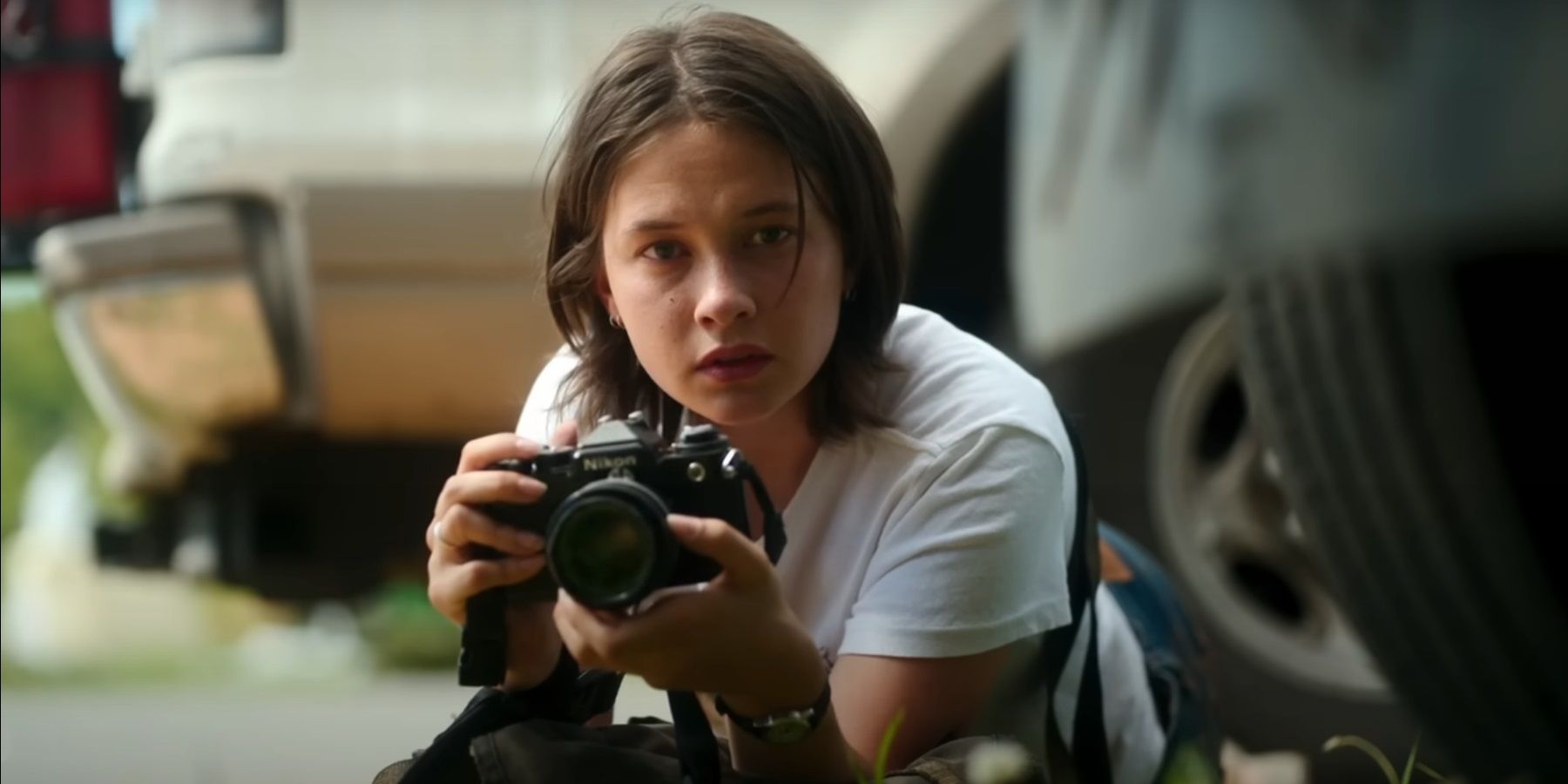 Cailee Spaeny as Jessie in Civil War. She is holding a camera.