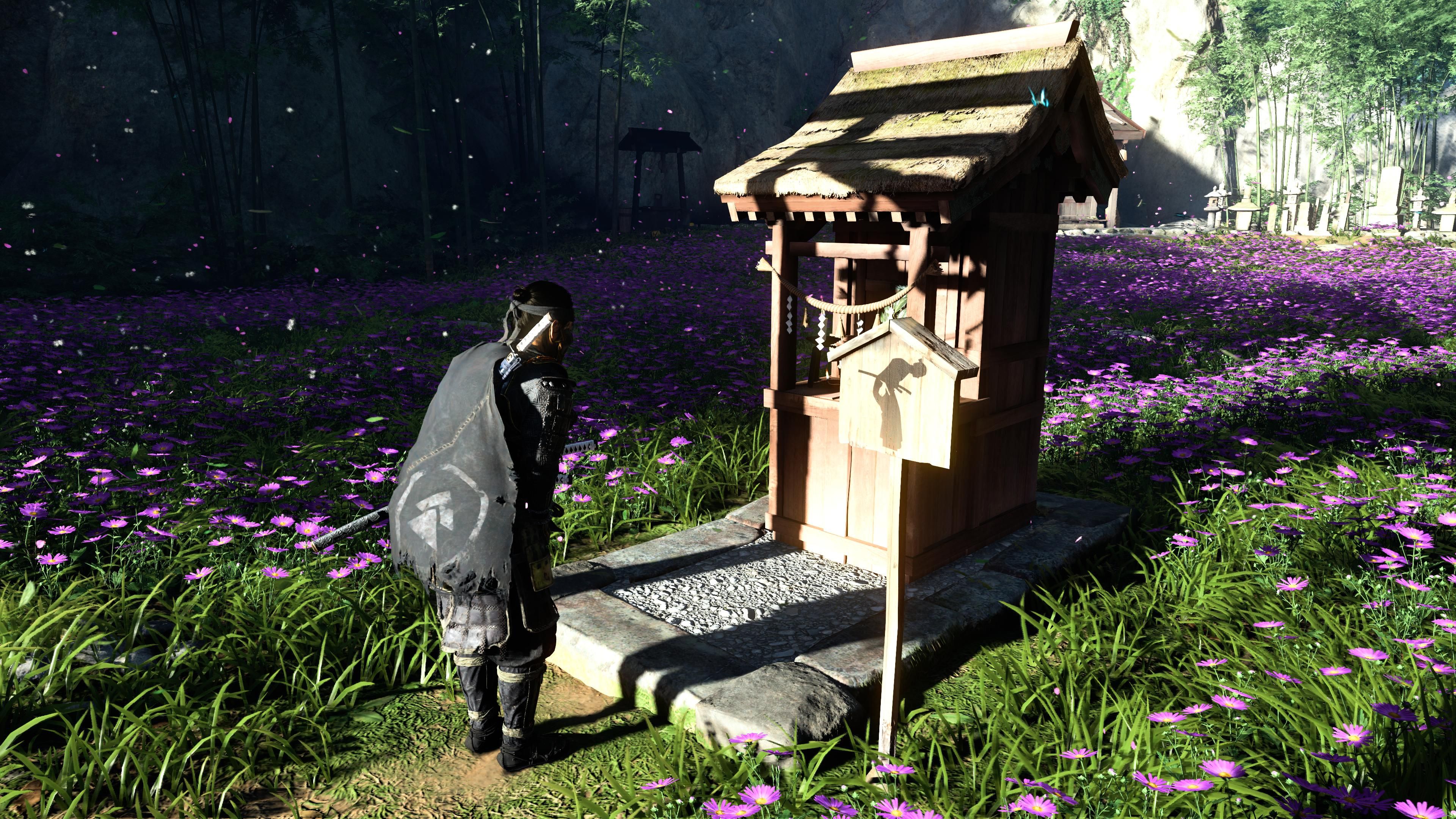 Jin curvando-se ao altar oculto no campo de flores roxas em Ghost Of Tsushima