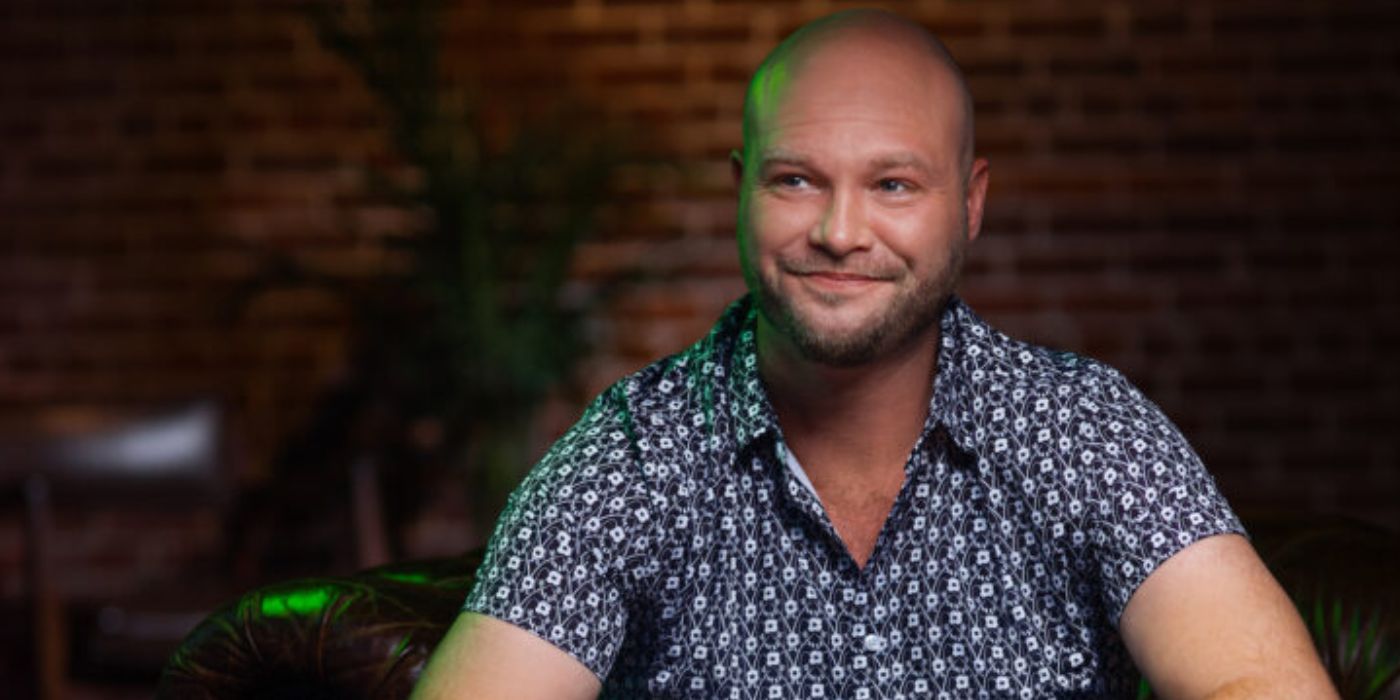 John McManus In 90 Day Fiance in printed shirt and smiling during promo shoot for single life