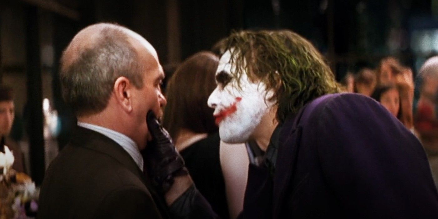 Joker gets in the face of a Gothamite at a party in The Dark Knight